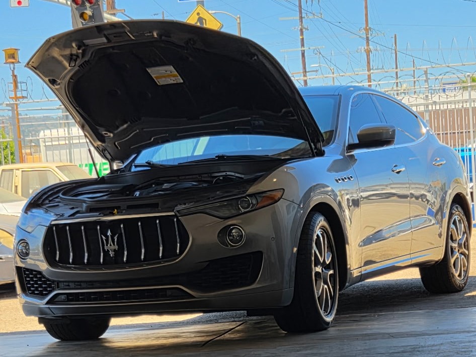 Maserati Levante with its hood open in a Gonzalez Auto Mechanic service bay